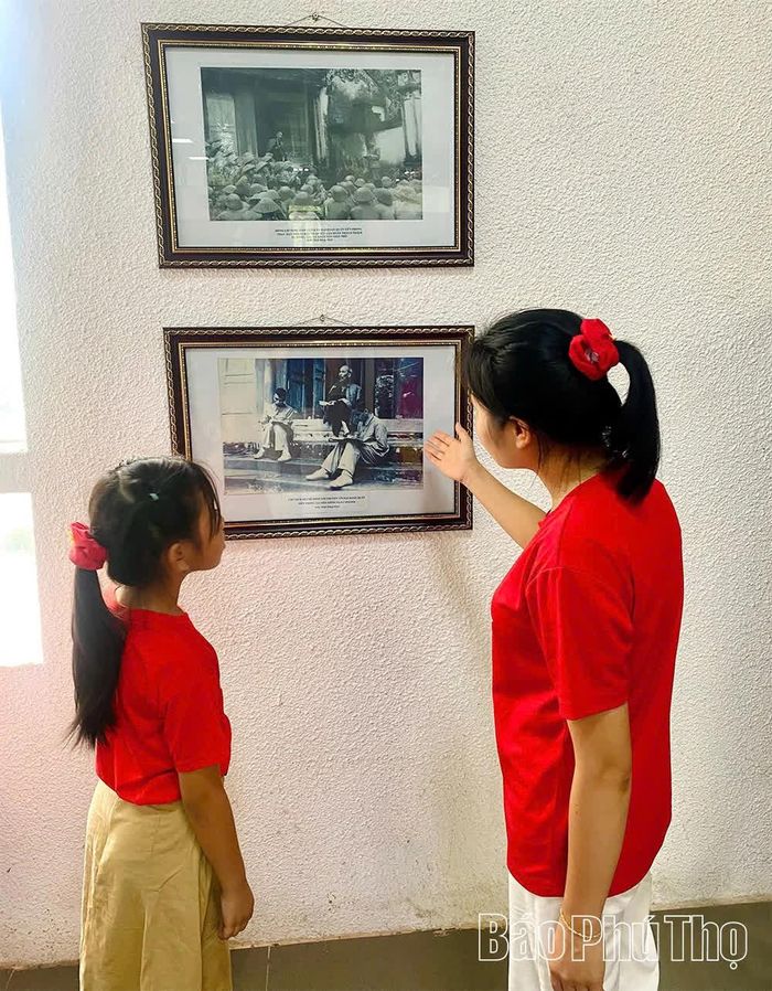 Các em học sinh tìm hiểu hình ảnh Bác Hồ nói chuyện với cán bộ, chiến sĩ Đại đoàn Quân Tiên phong tại Đền Hùng.