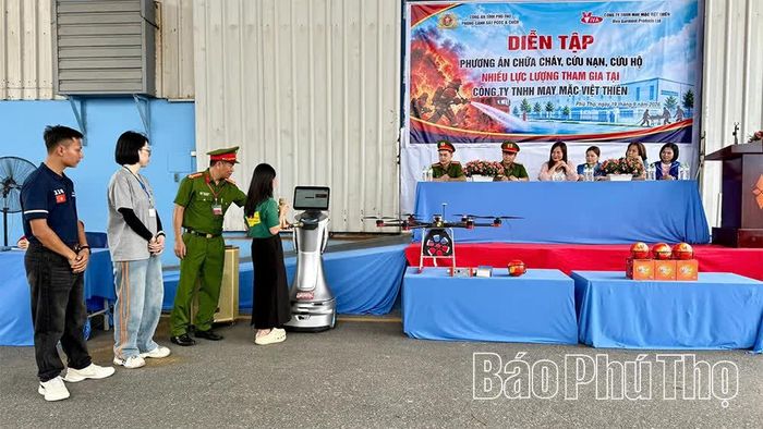 Công nhân Công ty TNHH May mặc Việt Thiên trải nghiệm sử dụng Robot AI giải đáp các câu hỏi liên quan đến công tác phòng cháy, chữa cháy.