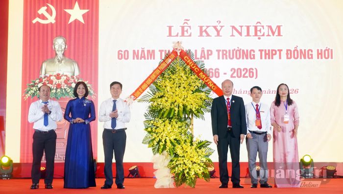 Đại diện lãnh đạo phường Đồng Sơn tặng hoa chúc mừng Trường THPT Đồng Hới - Ảnh: N.M