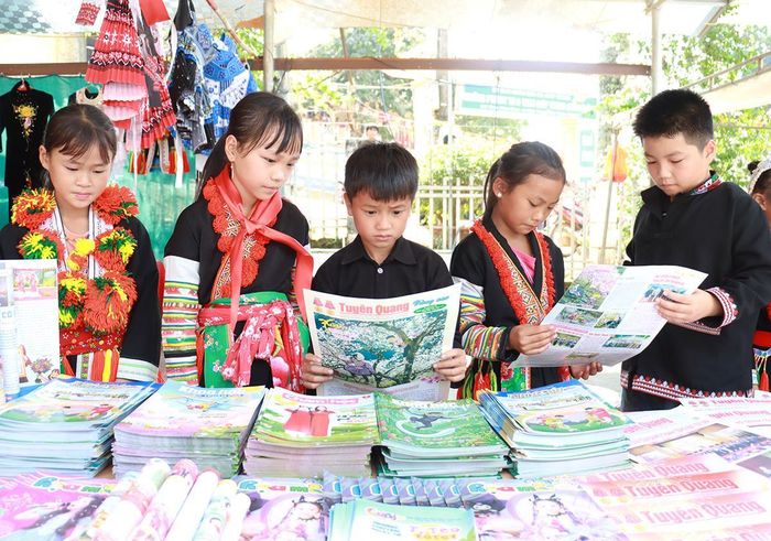Học sinh xã Giáp Trung đọc các ấn phẩm của Báo và phát thanh, truyền hình Tuyên Quang.