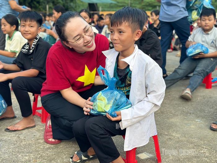 Đại diện Chương trình thiện nguyện “Ấm vùng cao” trao quà cho các em học sinh.
