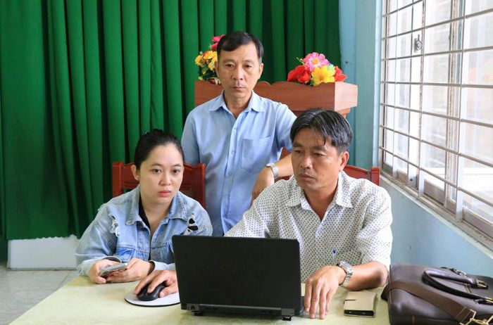 Chị Huỳnh Thị Kiều Trinh đang được cán bộ hướng dẫn trích lục khai sinh trực tuyến tại trụ sở ấp