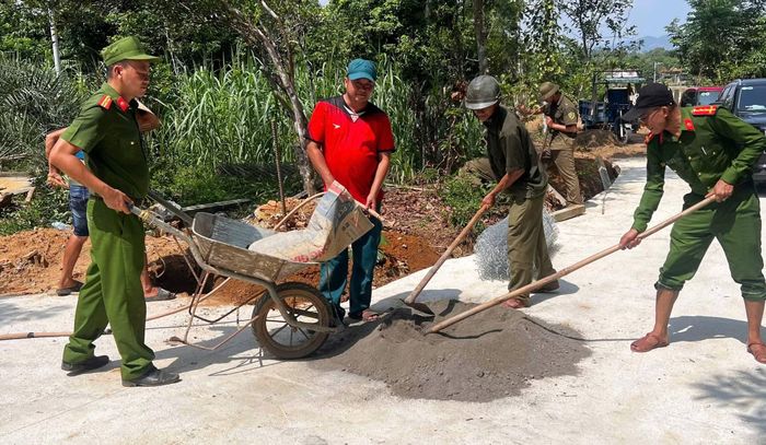 Cán bộ Công an xã Chiên Đàn trộn bê tông để đổ móng giữ trụ rào.