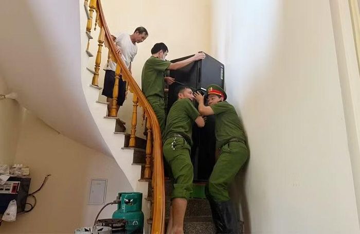 Công an phường Hàm Rồng hỗ trợ người dân sắp xếp lại đồ đạc sau khi nước rút.