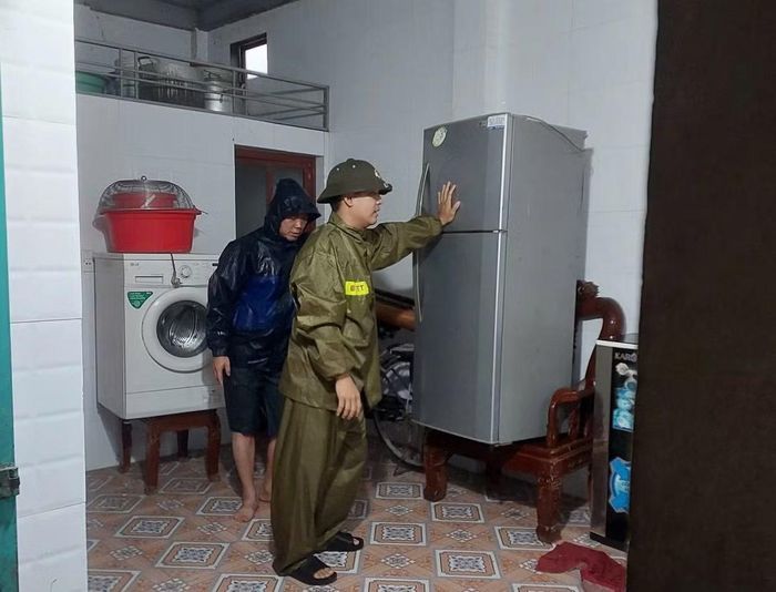 Công an xã Mỹ Đức cùng lực lượng tham gia bảo vệ ANTT ở cơ sở hỗ trợ người dân di dời tài sản đến nơi an toàn.
