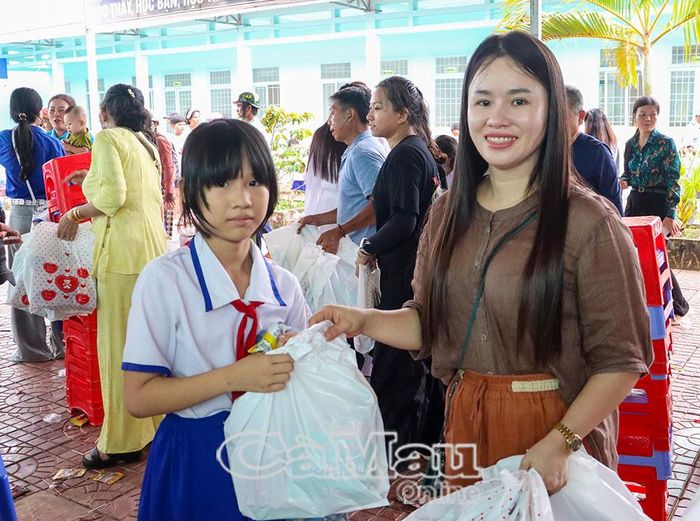  Chị Phạm Thị Luận, thành viên Nhóm thiện nguyện Thành phố Hồ Chí Minh, trao quà Trung thu cho học sinh Trường Tiểu học Trịnh Minh Hưởng.