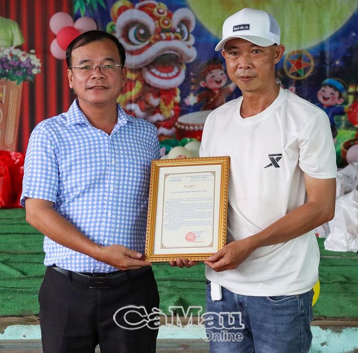  Phó Chủ tịch UBND xã Khánh Lâm Trần Công Mười (bên trái) trao thư cảm ơn đến Nhóm thiện nguyện Thành phố Hồ Chí Minh.