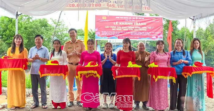 Các đại biểu thực hiện nghi thức cắt băng khánh thành cầu giao thông nông thôn Số 1 tại ấp Công Điền, xã Long Điền.