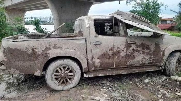 Chiếc xe được trục vớt lên bờ. Ảnh: Thanh Niên