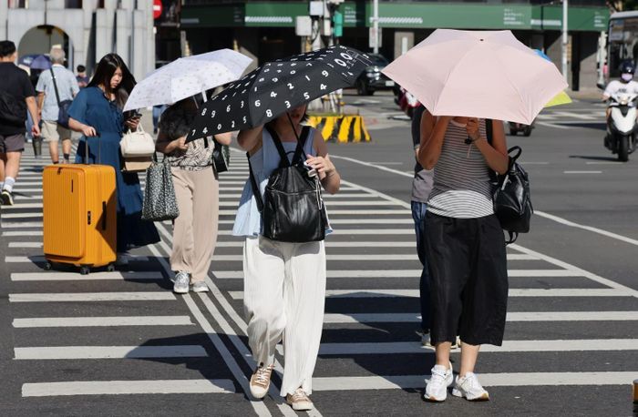 Người đi bộ che ô dưới cái nắng gay gắt ở Đài Bắc, Đài Loan, Trung Quốc. (Ảnh: EPA)