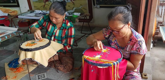 Người dân làng nghề thêu Quất Động miệt mài từng đường kim mũi chỉ. Ảnh: Vân Nga
