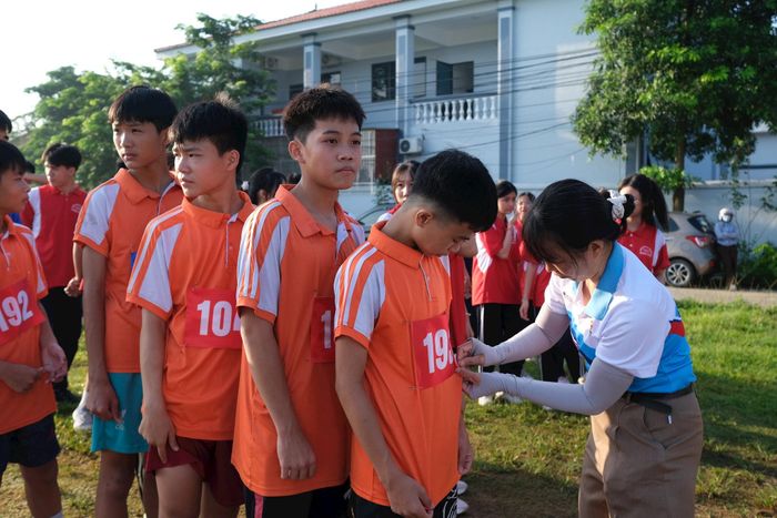 Trọng tài gắn số cho các học sinh trường Tiểu học và THCS Tân Dân trước khi bước vào thi đấu. Ảnh: Sỹ Hào