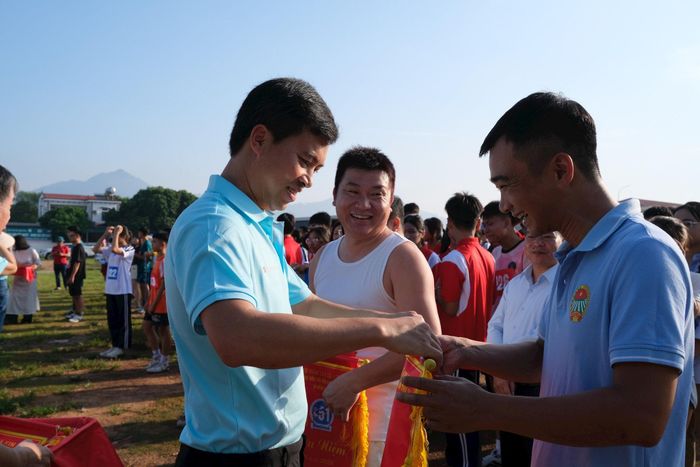 Phó Chủ tịch UBND xã Kim Anh Đoàn Hiệp (bên trái), tặng cờ lưu niệm cho các vận động viên tham gia giải chạy. Ảnh: Sỹ Hào