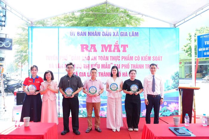 Lãnh đạo xã Gia Lâm trao biểu trưng chứng nhận cho đại diện các cơ sở kinh doanh đạt tiêu chuẩn an toàn thực phẩm trên địa bàn. Ảnh: P.V