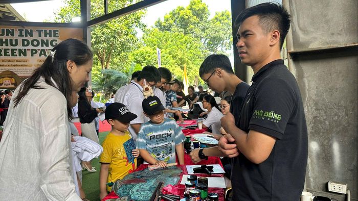 Các em học sinh tìm hiểu và trải nghiệm kỹ thuật in môc bản. Ảnh: Nguyễn Thủy