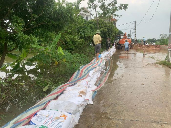 Sau 2 giờ thi công, xã Quảng Bị đã tôn cao đê tả Bùi (phía sông) chống lũ tràn vào công trình (phía đồng) và đồng ruộng. Ảnh: Quang Đông