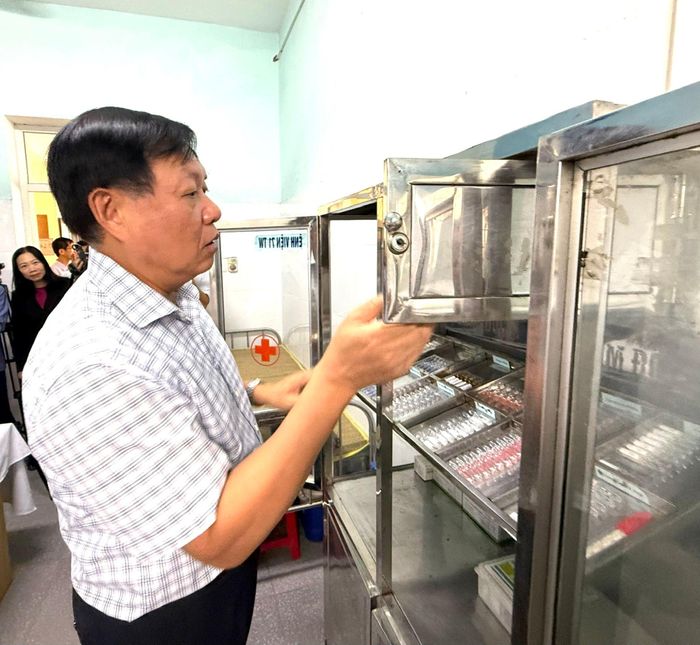 Thứ trưởng Bộ Y tế Đỗ Xuân Tuyên kiểm tra tủ thuốc tại một trạm y tế xã của tỉnh Ninh Bình.  Ảnh: Thái Bình