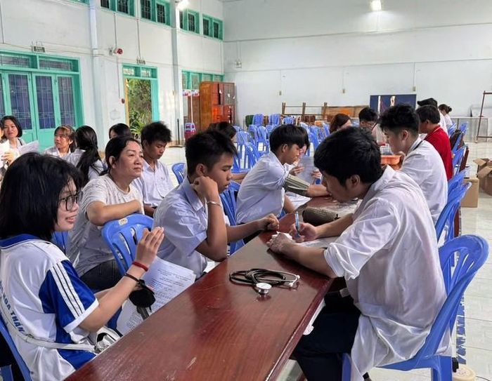 Các em học sinh Trường THPT Hoàng Hoa Thám được bác sĩ khám miễn phí và tư vấn kỹ càng. Ảnh: D. Long.