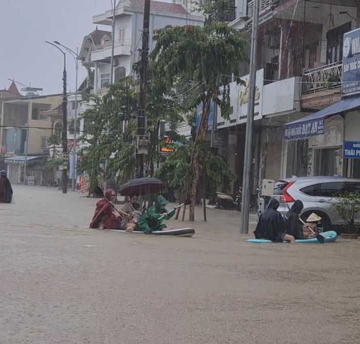 Mưa lớn khiến nhiều tuyến phố ở TP Vinh (cũ) ngập sâu, người dân chèo thuyền để di chuyển giữa phố. Ảnh: V. Đồng