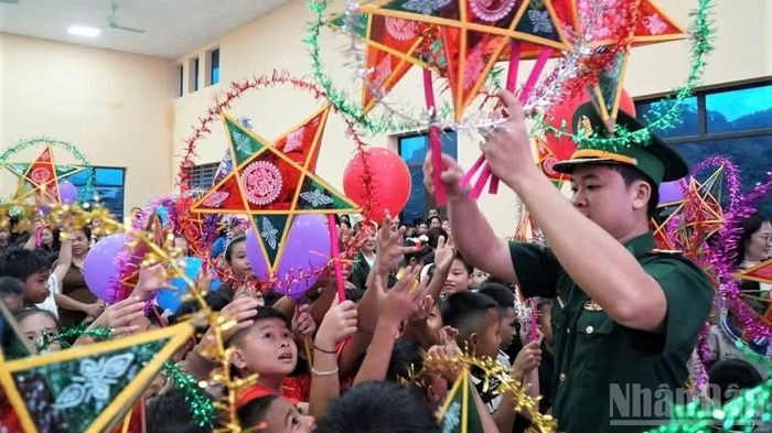 Các em nhỏ háo hức đón lấy chiếc đèn ông sao năm cánh truyền thống.