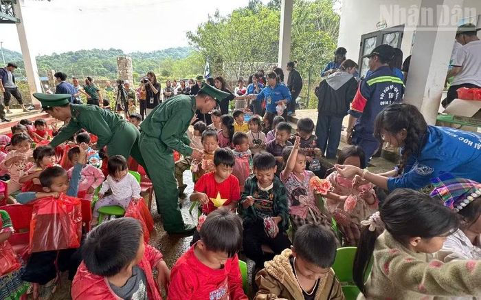 Cán bộ, chiến sĩ Đồn Biên phòng Lóng Sập cùng các đơn vị tài trợ trao quà nhân dịp Tết Trung thu cho các em thiếu nhi. (Ảnh: QUÀNG HÙNG)