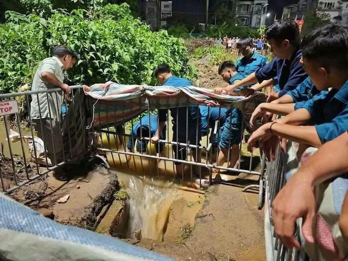 Lực lượng cứu hộ cứu nạn tìm thi thể nam sinh viên rơi xuống cống tử vong tại phường Đông Ngạc. (Ảnh: Đức Tuấn)
