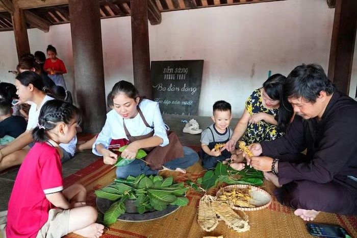 Các nghệ nhân hướng dẫn các cháu bé bện rơm, gấp lá thành các con vật ngộ nghĩnh. (Ảnh: HÀ THÀNH)
