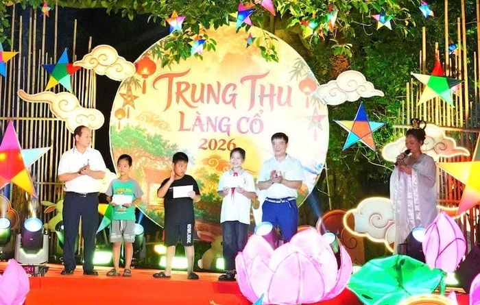 Lãnh đạo phường Đường Lâm trao quà cho các cháu nhỏ có hoàn cảnh khó khăn. (Ảnh: HÀ THÀNH)