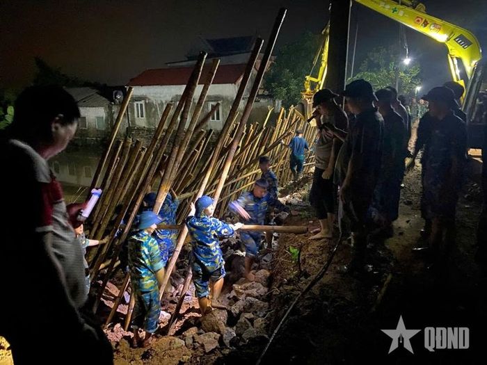 Cán bộ, chiến sĩ Tiểu đoàn 64, Trung đoàn 260, Sư đoàn 361 (Quân chủng Phòng không - Không quân) cùng các lực lượng giúp nhân dân xã Phú Nghĩa, TP Hà Nội gia cố đê tả sông Bùi.