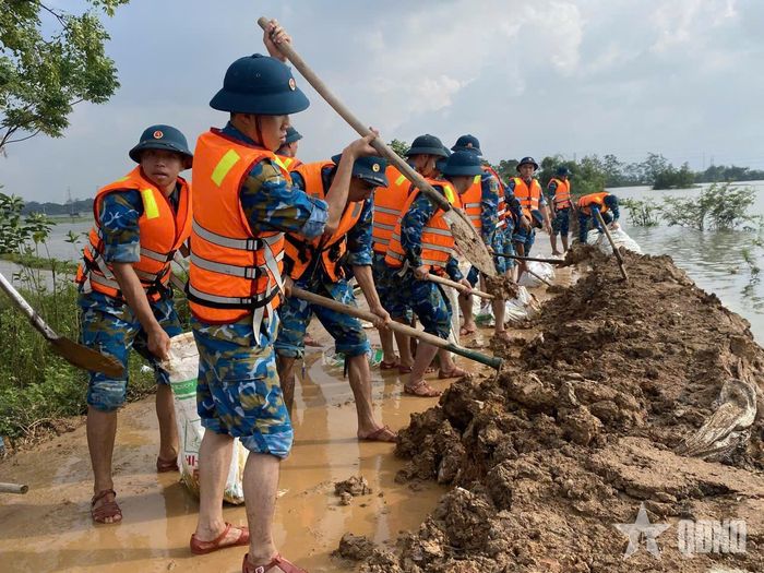 Cán bộ, chiến sĩ Tiểu đoàn 64, Trung đoàn 260, Sư đoàn 361 (Quân chủng Phòng không-Không quân) cùng các lực lượng giúp nhân dân xã Phú Nghĩa, TP Hà Nội gia cố đê tả sông Bùi.