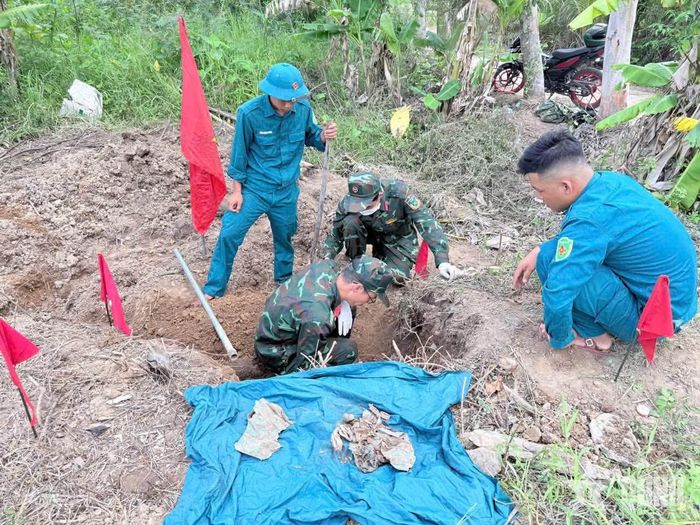 Lực lượng chức năng khai quật, cất bốc hài cốt liệt sĩ.