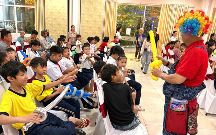 Thiếu nhi tham gia ngày hội Mùa trăng yêu thương 2026 nhận quà bong bóng từ chú hề. Ảnh: THÁI PHƯƠNG