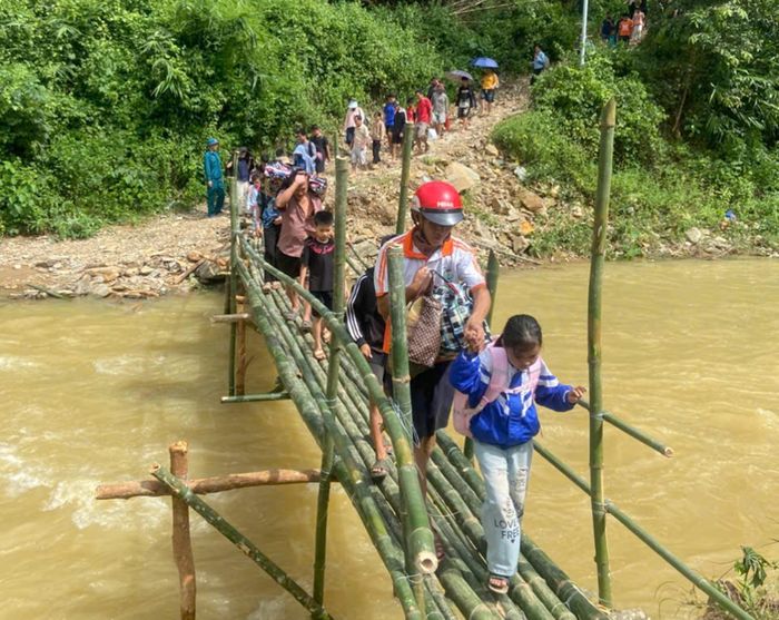 Học sinh được lực lượng chức năng hỗ trợ qua cầu tạm để kịp đến trường trong buổi học đầu tuần