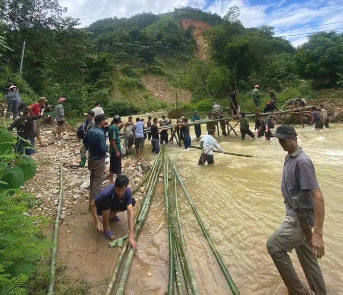 Lực lượng chức năng và người dân bắc cầu tre qua khe Chà Hạ