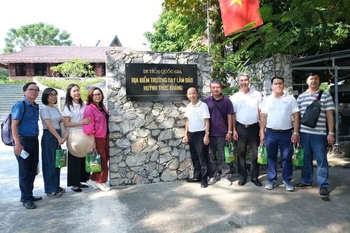 Các đại biểu chụp ảnh lưu niệm tại Di tích lịch sử Quốc gia Trường Dạy làm báo Huỳnh Thúc Kháng.
