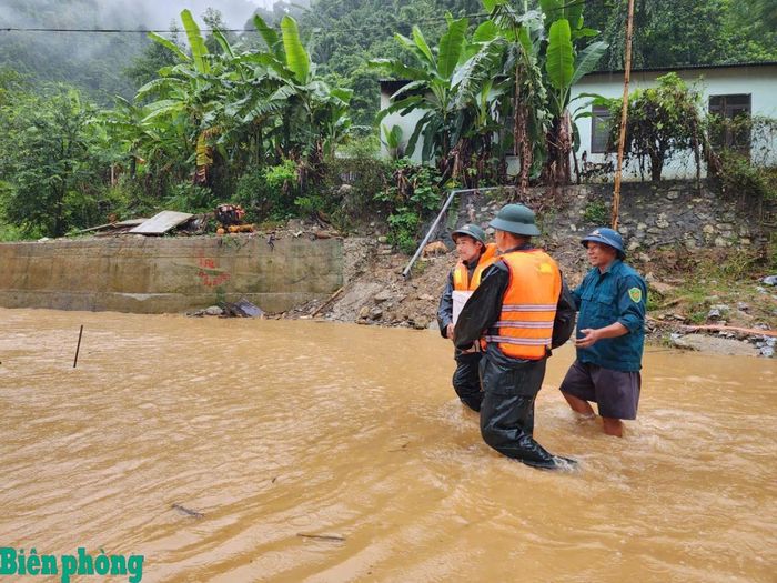 Cán bộ Đồn Biên phòng Tam Hợp, Bộ đội Biên phòng tỉnh Nghệ An và Ban Chỉ huy Quân sự xã Tam Thái vượt dòng nước lũ, mang cơm đến cho học sinh tại khu vực bị chia cắt. Ảnh: Lê Thạch