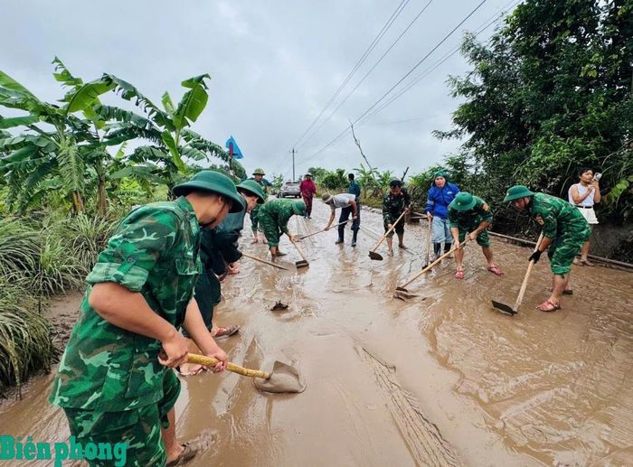 Cán bộ, chiến sĩ Bộ đội Biên phòng tỉnh Quảng Trị phối hợp với chính quyền địa phương và nhân dân dọn bùn đất trên các tuyến đường sau mưa lớn. Ảnh: Đình Tiến
