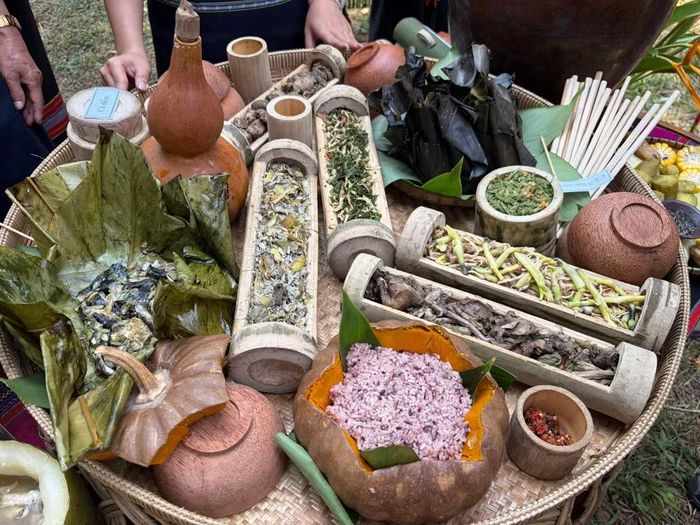 Bánh nếp cùng các lễ vật như gà luộc, cá nướng, thịt heo, rau, rượu cần và trầu cau được bày biện trang trọng trên mâm cúng. Ảnh: BTC