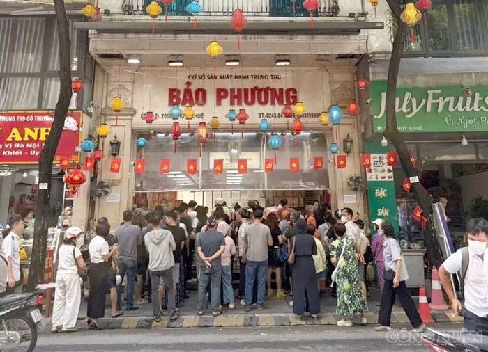 Người dân đứng kín và xếp hàng chờ mua bánh trung thu ở cửa hàng trên phố Thuỵ Khuê.