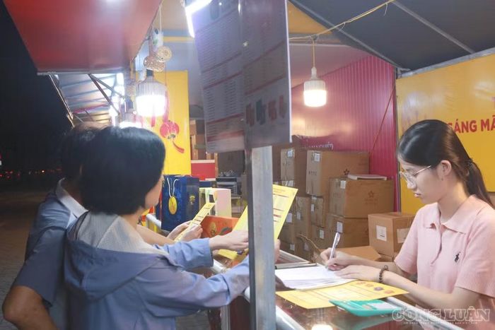 Người dân đến tham khảo giá bánh Trung thu được bán trong các gian hàng bên vỉa hè.