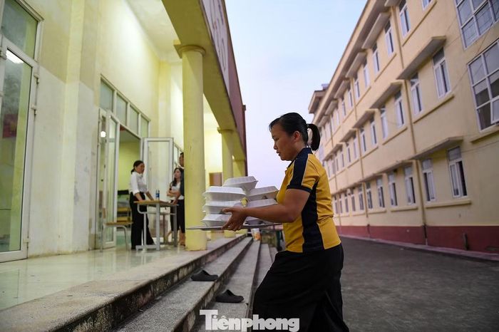 Đúng bữa, những khay cơm nóng sốt nhanh chóng được chuyển từ sân vào tận tay từng người dân, giúp bà con vơi bớt nỗi nhọc nhằn nơi tạm cư.