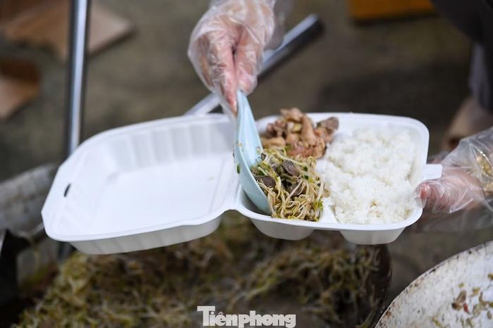 Ngay trong sân trường, một bếp ăn dã chiến được dựng lên. Cán bộ xã, lực lượng dân quân và tình nguyện viên cùng chuẩn bị thực phẩm, nấu ăn phục vụ người dân tại điểm tránh trú.