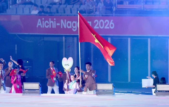  Quang Kiệt giương quốc kỳ khi Đoàn Thể thao Việt Nam diễu hành. Nhiệm vụ tại lễ khai mạc đánh dấu cột mốc mới của cầu thủ vừa vô địch ASEAN Cup 2026 và chuyển sang khoác áo CLB Công an TPHCM. Ảnh: M.D. 
