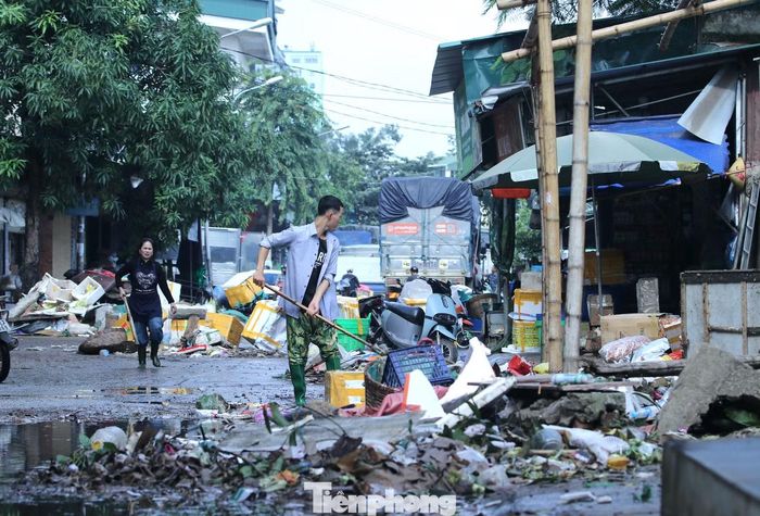 Rác từ hàng hoá bị hư hỏng theo dòng nước tràn khắp nơi.