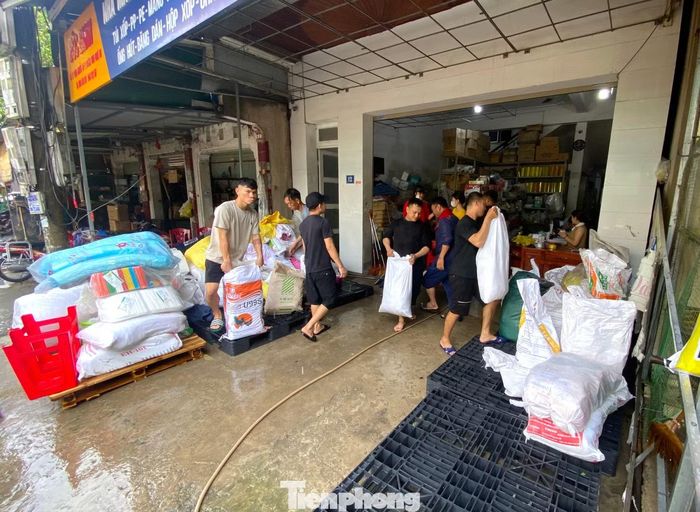 Sau khi nước rút, cửa hàng Đức Bình buôn bán phía sau chợ Vinh phải thuê nhiều người đến dỡ hàng hoá ra để phân loại và lau chùi.