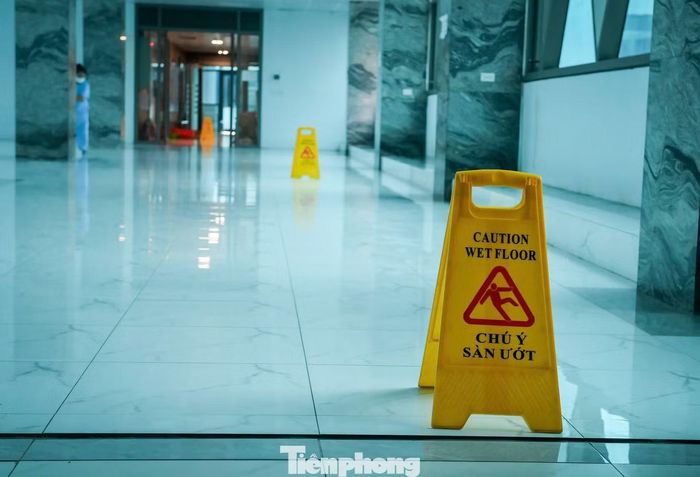 Sảnh tầng 2, Khoa Truyền nhiễm cũng trong tình trạng tương tự. Bệnh viện phải đặt nhiều biển cảnh báo sàn ướt để cảnh báo người bệnh và người nhà chú ý khi đi lại qua khu vực.