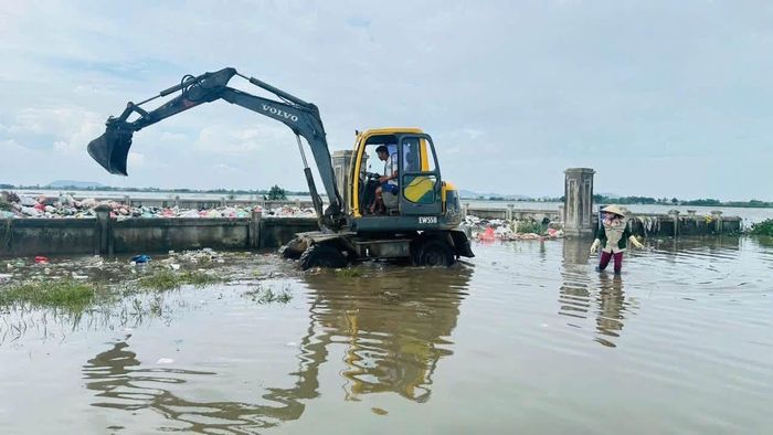 Huy động máy móc, nhân lực để xử lý rác sinh hoạt trôi nổi sau lũ.