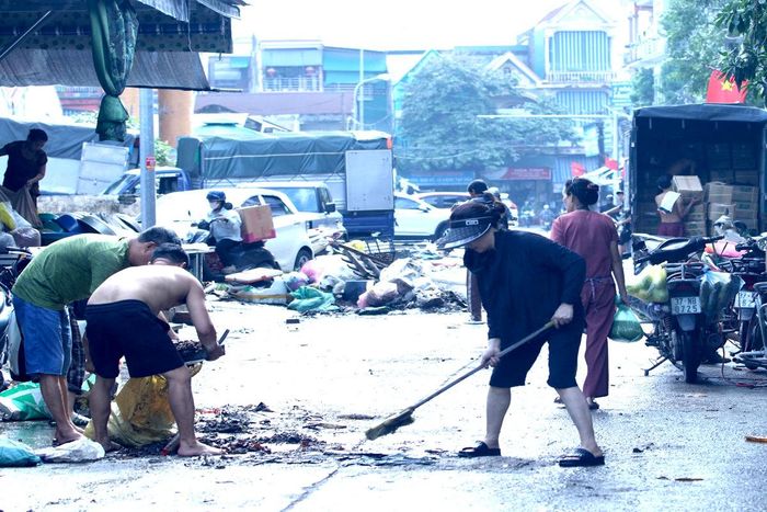 Bùn đất, rác thải còn sót lại sau khi nước rút được tiểu thương thu gom, dọn sạch.