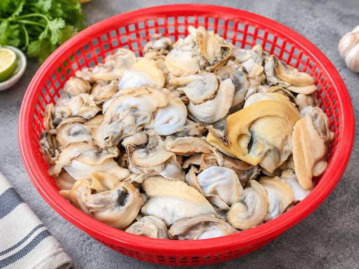 Tách thịt trai và bỏ phần ruột đen, mép cứng. Ảnh minh họa: AI