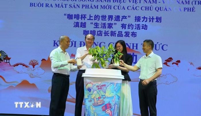 Đại biểu thực hiện hoạt động tưới nước cho cây càphê tại chương trình. (Ảnh: Công Luật/TTXVN)